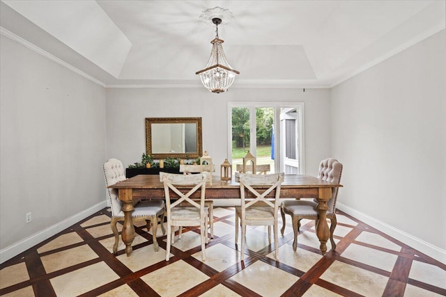 dining space featuring inlaid floor details, a raised ceiling, baseboards, and crown molding