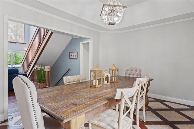 dining room with inlaid floor details, a chandelier, baseboards, and ornamental molding
