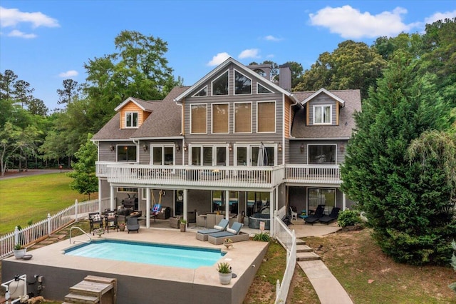 back of house with an outdoor living space, a patio area, a chimney, and a shingled roof