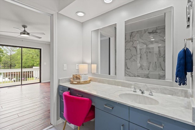 bathroom featuring vanity, baseboards, a shower, and ceiling fan