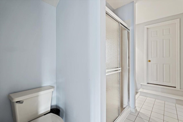 bathroom featuring tile patterned flooring, a stall shower, and toilet
