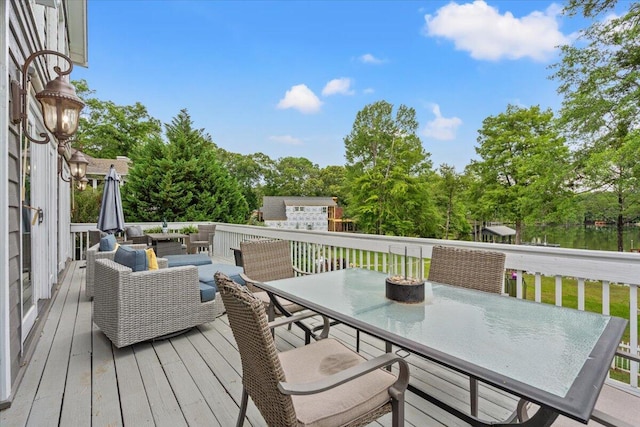 wooden deck featuring outdoor dining space, outdoor lounge area, and view of wooded area