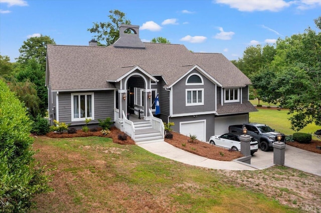 view of front of home with a front yard, roof with shingles, an attached garage, driveway, and a chimney