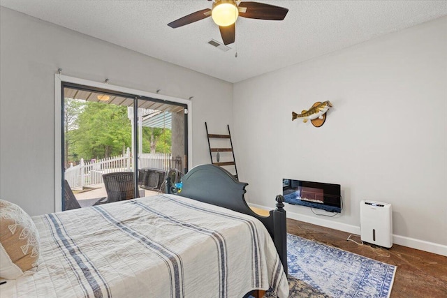 bedroom featuring access to outside, baseboards, a textured ceiling, a ceiling fan, and heating unit