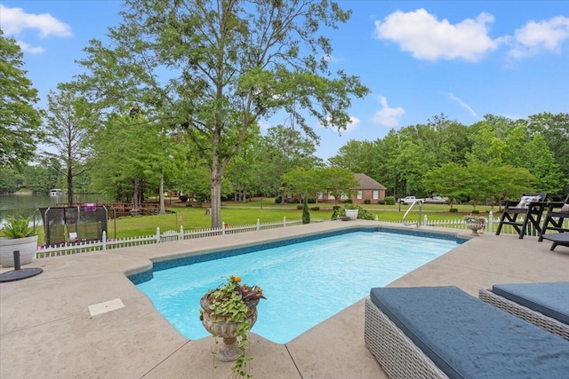swimming pool featuring a patio area and view of scattered trees