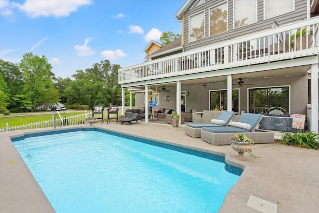 rear view of house featuring a balcony, a ceiling fan, and outdoor lounge area