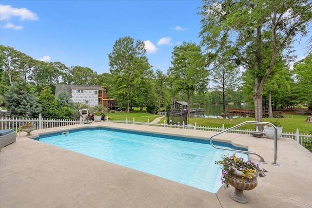 view of swimming pool featuring a patio and view of scattered trees