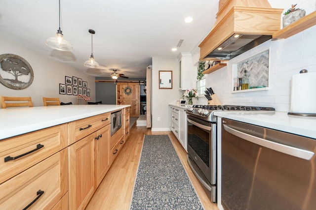 kitchen with premium range hood, light brown cabinetry, decorative light fixtures, light hardwood / wood-style floors, and stainless steel appliances