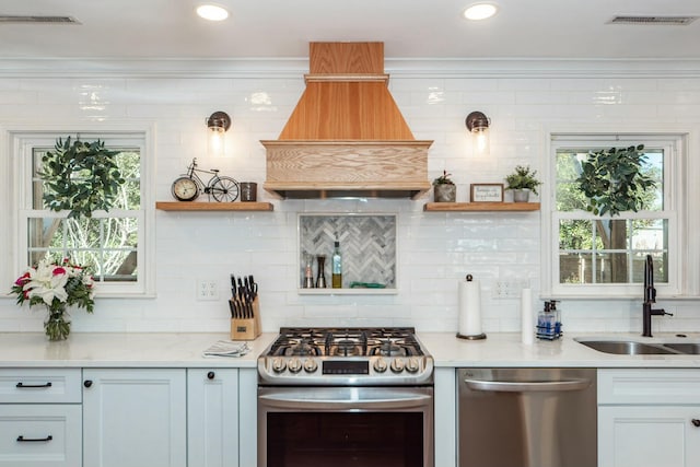 kitchen featuring stainless steel appliances, crown molding, and sink