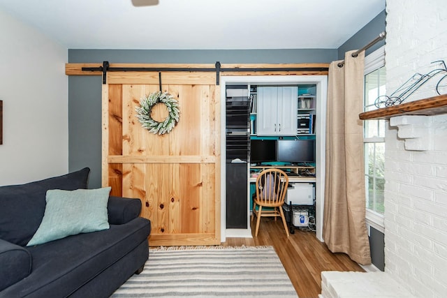 living room featuring a barn door, a healthy amount of sunlight, and light wood-type flooring