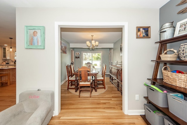 dining area with an inviting chandelier and light hardwood / wood-style floors