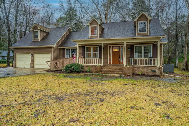 new england style home with cooling unit, driveway, a porch, a front lawn, and a garage