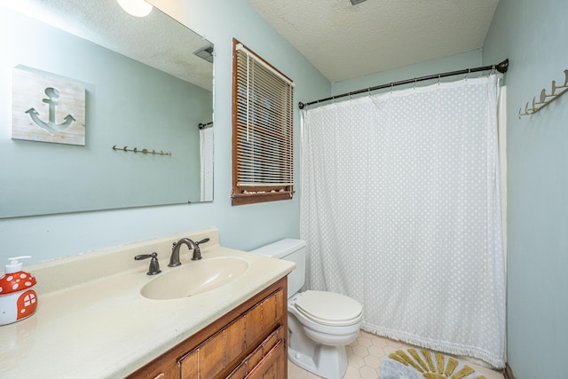 bathroom with tile patterned floors, toilet, vanity, and a textured ceiling