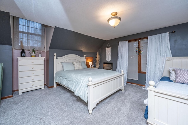 carpeted bedroom featuring baseboards, lofted ceiling, and a textured ceiling