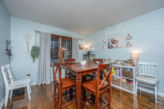 dining space featuring a textured ceiling, baseboards, and hardwood / wood-style floors