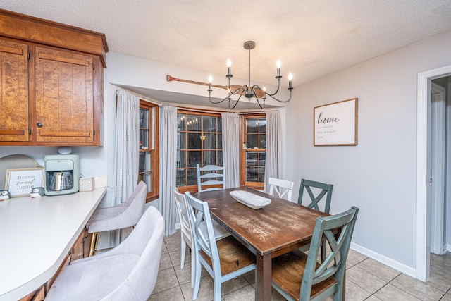 dining space with light tile patterned floors, baseboards, a chandelier, and a textured ceiling