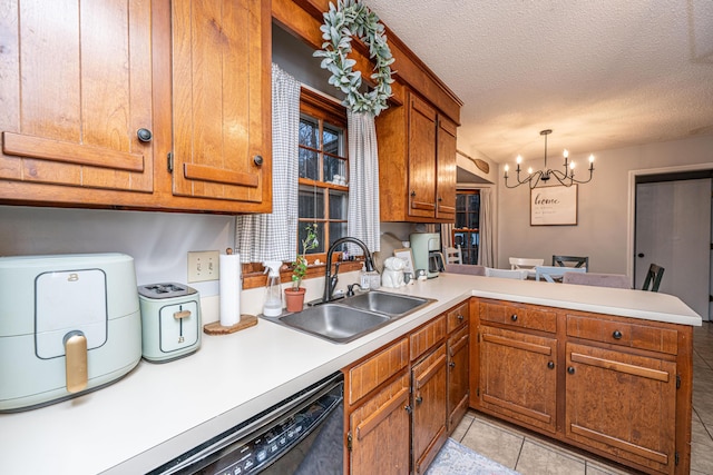 kitchen with brown cabinetry, a peninsula, light countertops, and a sink