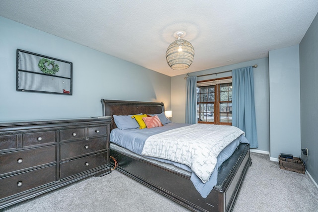 carpeted bedroom featuring baseboards and a textured ceiling