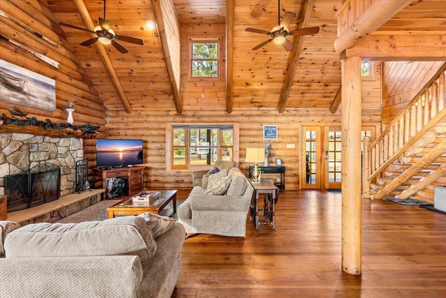 3550 Princess Pond Rd, Summerton, SC 29148 - living room with a ceiling fan, wood ceiling with exposed beams, a stone fireplace, rustic walls, and hardwood / wood-style floors