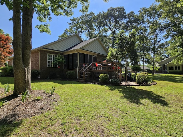 rear view of property featuring a sunroom, a yard, a wooden deck, and stairs