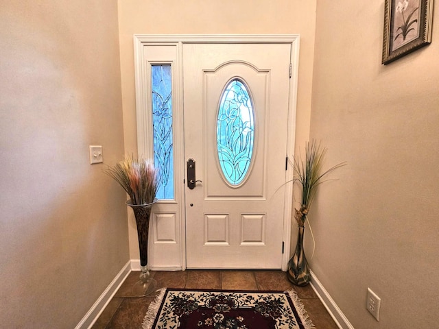entryway with baseboards and dark tile patterned flooring