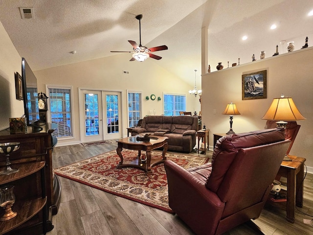 living room with ceiling fan, wood finished floors, a chandelier, high vaulted ceiling, and recessed lighting