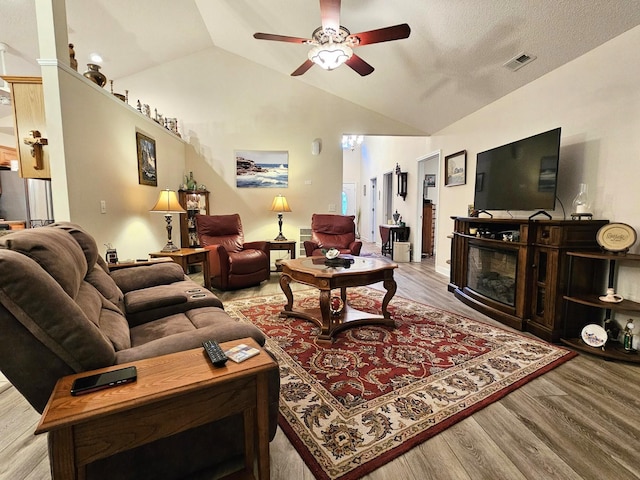 living room with wood finished floors, a ceiling fan, and vaulted ceiling