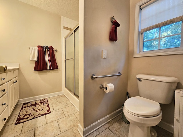 bathroom with baseboards, a shower stall, vanity, and toilet