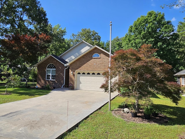 view of front of home featuring driveway, a garage, a front yard, and brick siding