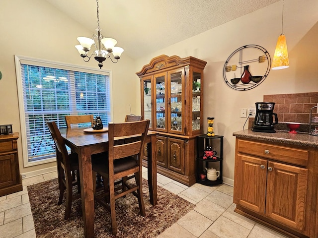 dining room with vaulted ceiling, a chandelier, light tile patterned floors, and a textured ceiling