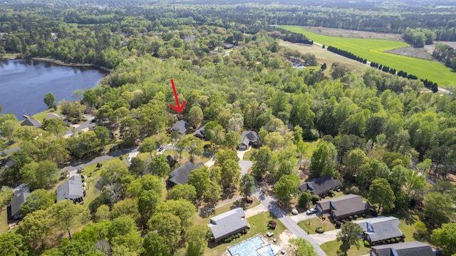 aerial view of property and surrounding area with a large body of water and a heavily wooded area