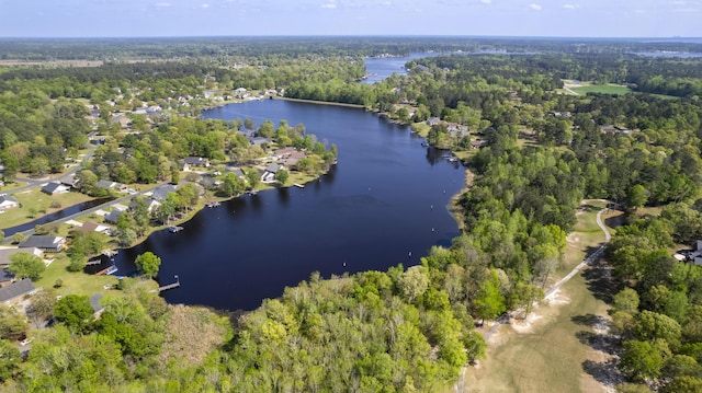 aerial overview of property's location with a nearby body of water and a heavily wooded area