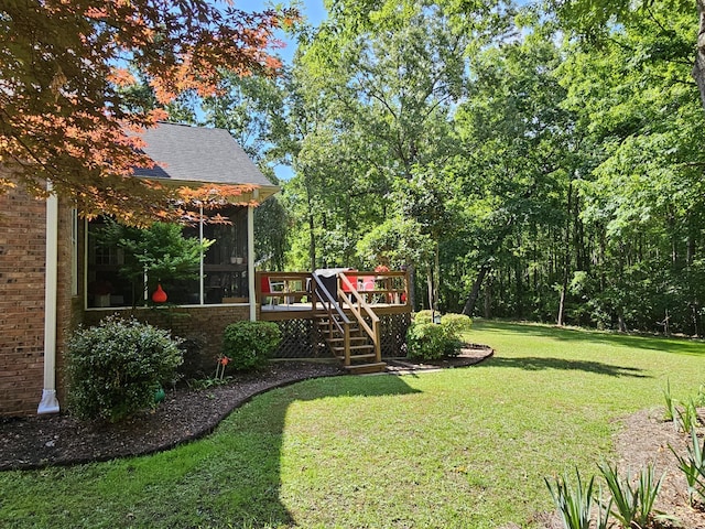view of grassy yard featuring a wooden deck, stairway, and a sunroom