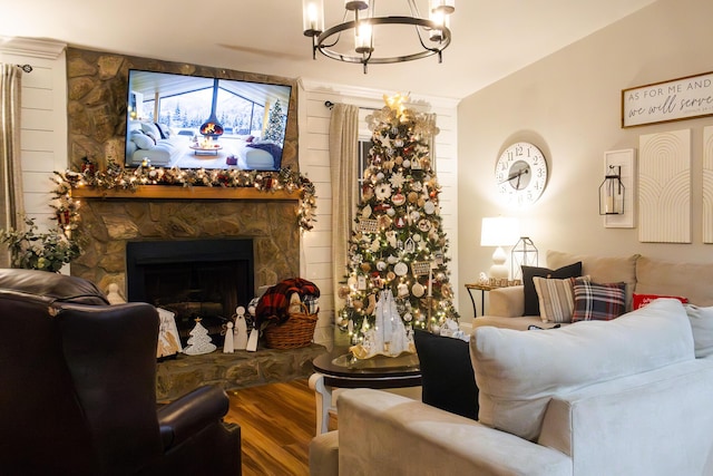 living room with a fireplace, hardwood / wood-style flooring, and an inviting chandelier