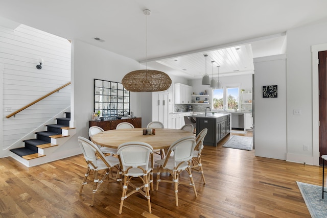 dining area with sink and light wood-type flooring