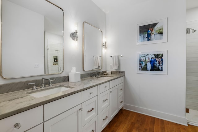 bathroom with hardwood / wood-style flooring, vanity, and walk in shower