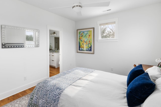 bedroom featuring connected bathroom, wood-type flooring, and ceiling fan