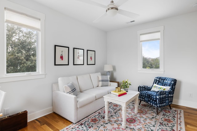 living room featuring ceiling fan, wood-type flooring, and a wealth of natural light