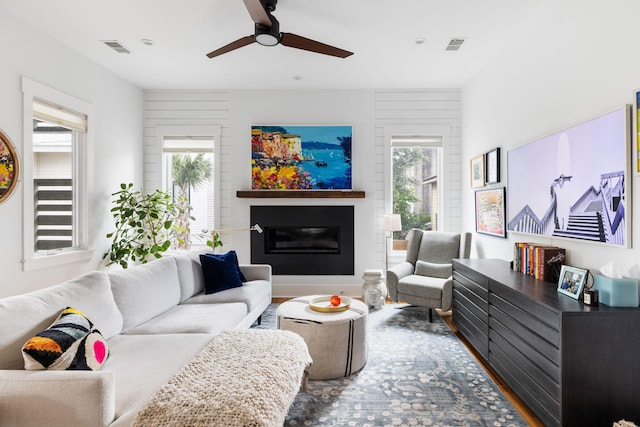 living room featuring ceiling fan, plenty of natural light, and wood-type flooring