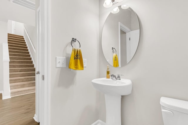 bathroom featuring hardwood / wood-style flooring and toilet