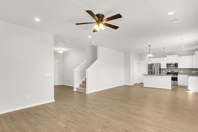 unfurnished living room with ceiling fan and light hardwood / wood-style floors