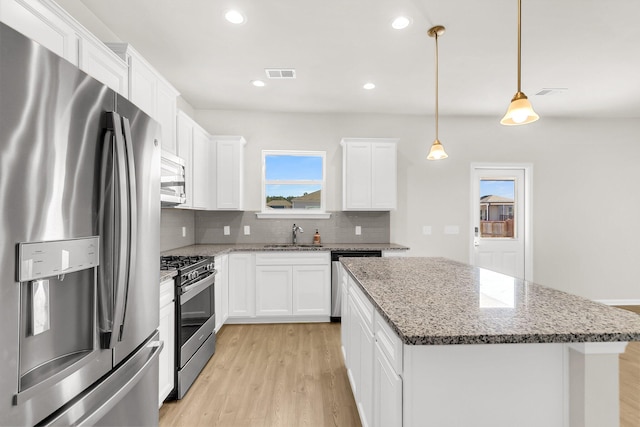 kitchen featuring appliances with stainless steel finishes, white cabinetry, and a kitchen island