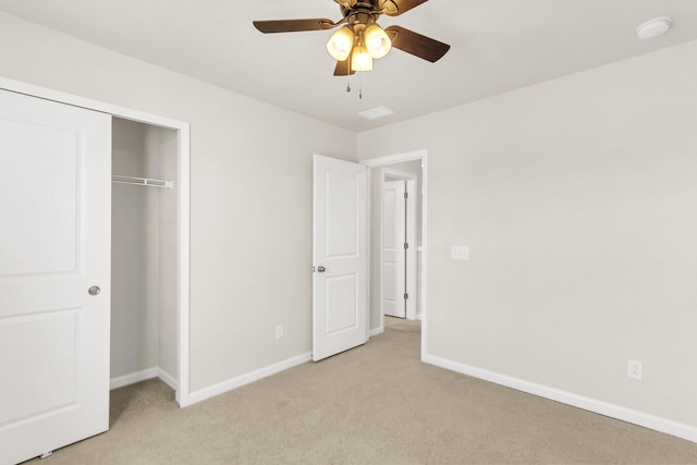 unfurnished bedroom featuring a closet, light colored carpet, and ceiling fan