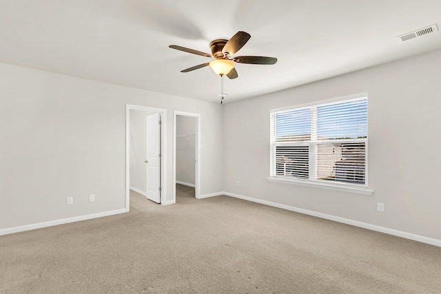 empty room featuring ceiling fan and light colored carpet