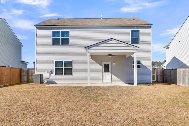 rear view of house with ceiling fan, central air condition unit, a patio, and a yard