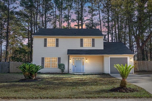 front of property with a garage and a lawn