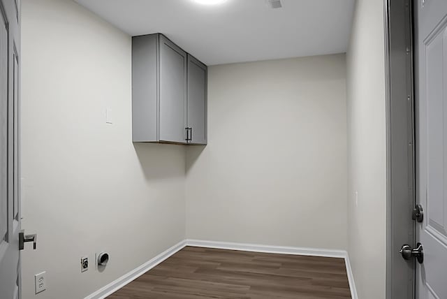 laundry room with cabinets, dark hardwood / wood-style flooring, and electric dryer hookup