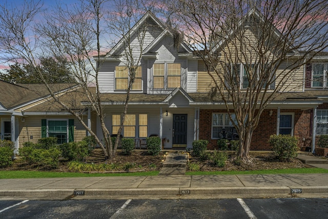 view of front of house with brick siding and uncovered parking