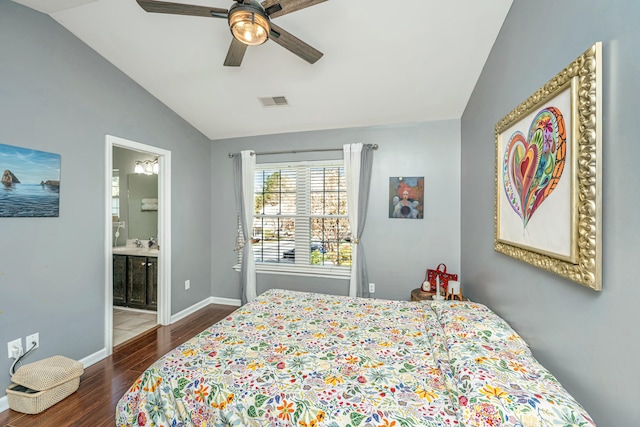 bedroom featuring visible vents, wood finished floors, connected bathroom, baseboards, and vaulted ceiling