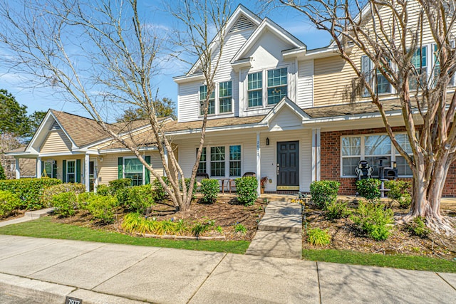 view of front of house featuring a porch and brick siding